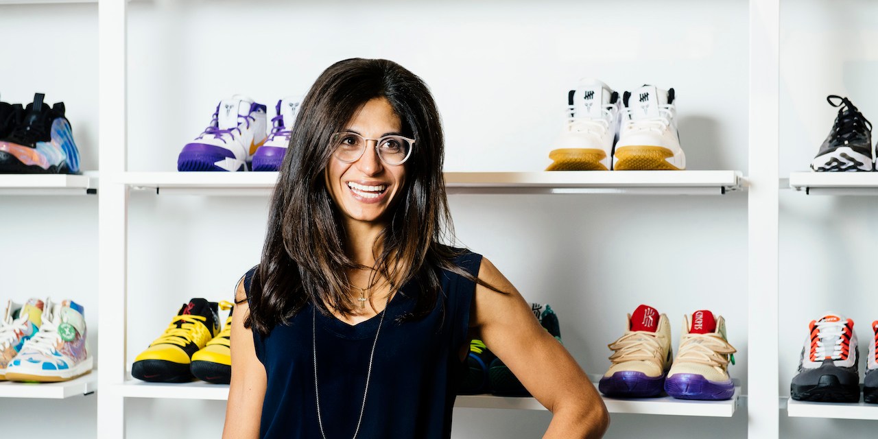 The header image shows Deena Bahri posing in front of a shelf of sneakers.