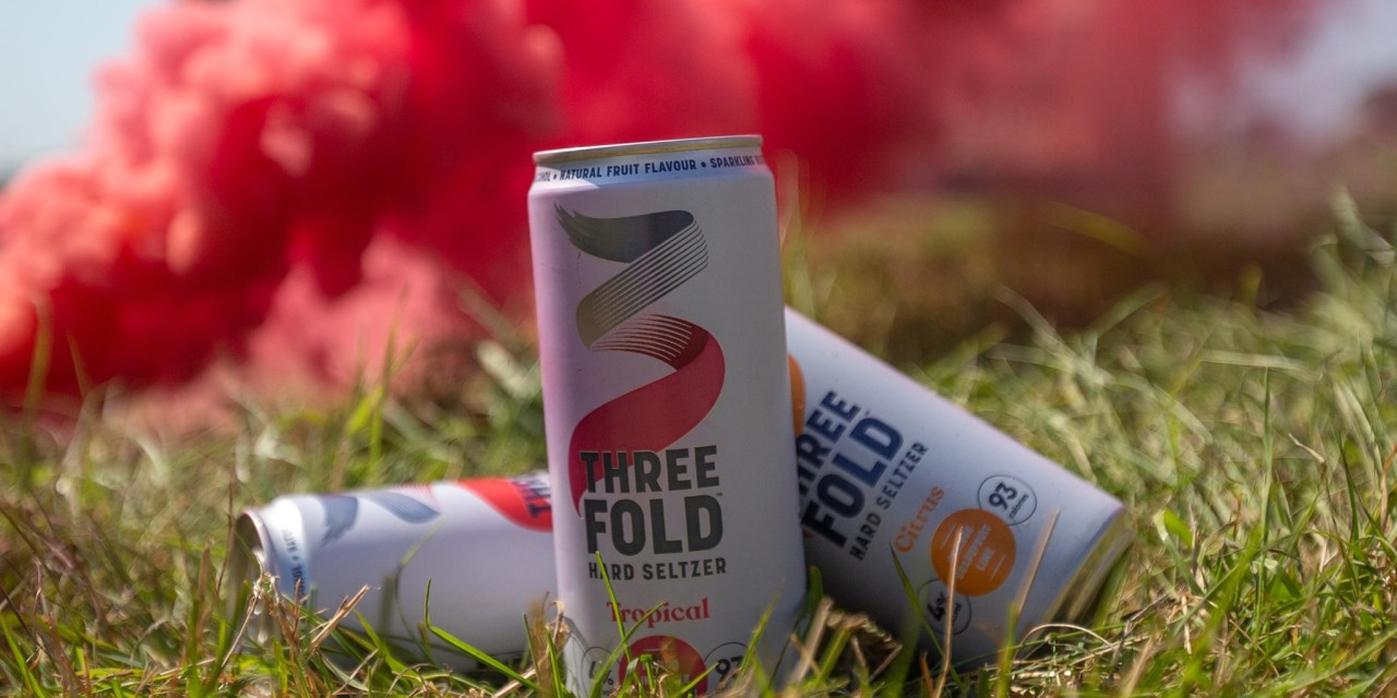 The header image shows a few cans of Three Fold hard seltzer.