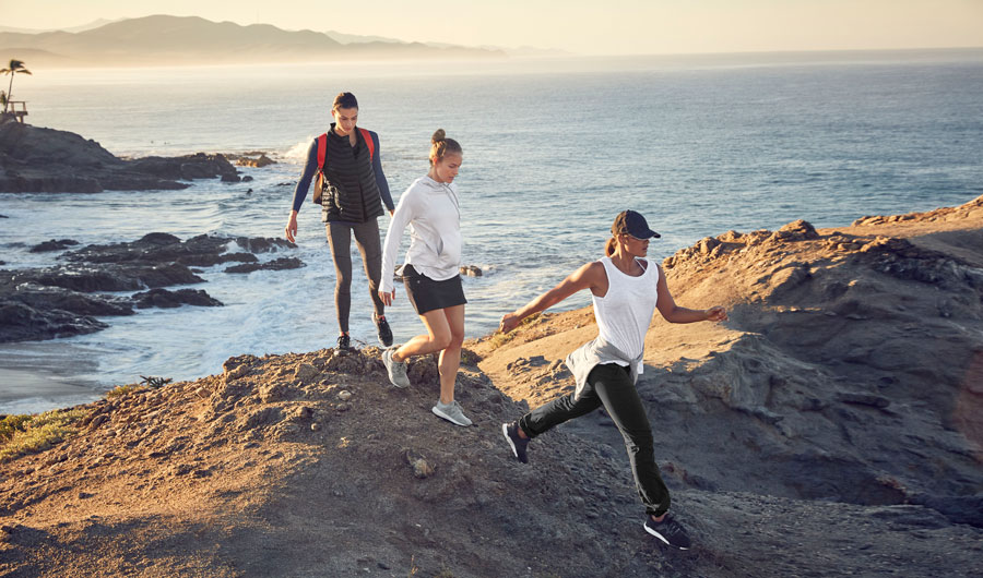 The lead image shows three people hiking in Athleta x REI clothing.