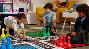 Photograph of children playing a large board game.