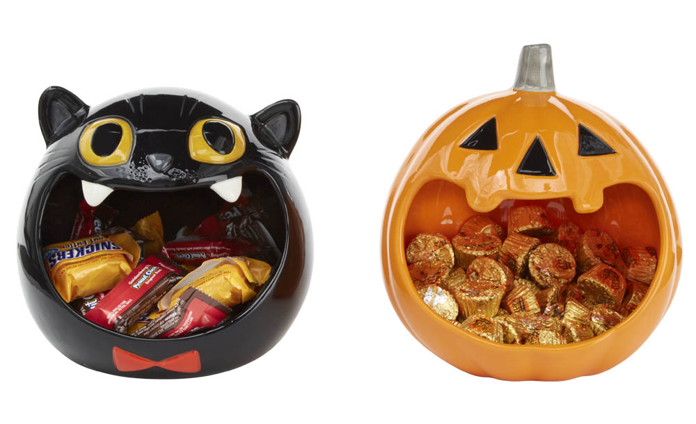 Pumpkin and cat-shaped candy bowls hold Reese's Peanut Butter Cups and Snicker's candy bars