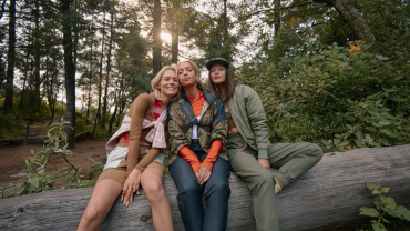 Women sitting on log in Merrell gear