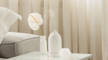 A white Vitruvi diffuser on a side table
