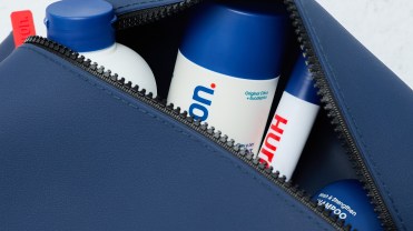 Blue toiletry bag with shampoo bottle, conditioner, deodorant and eye cream