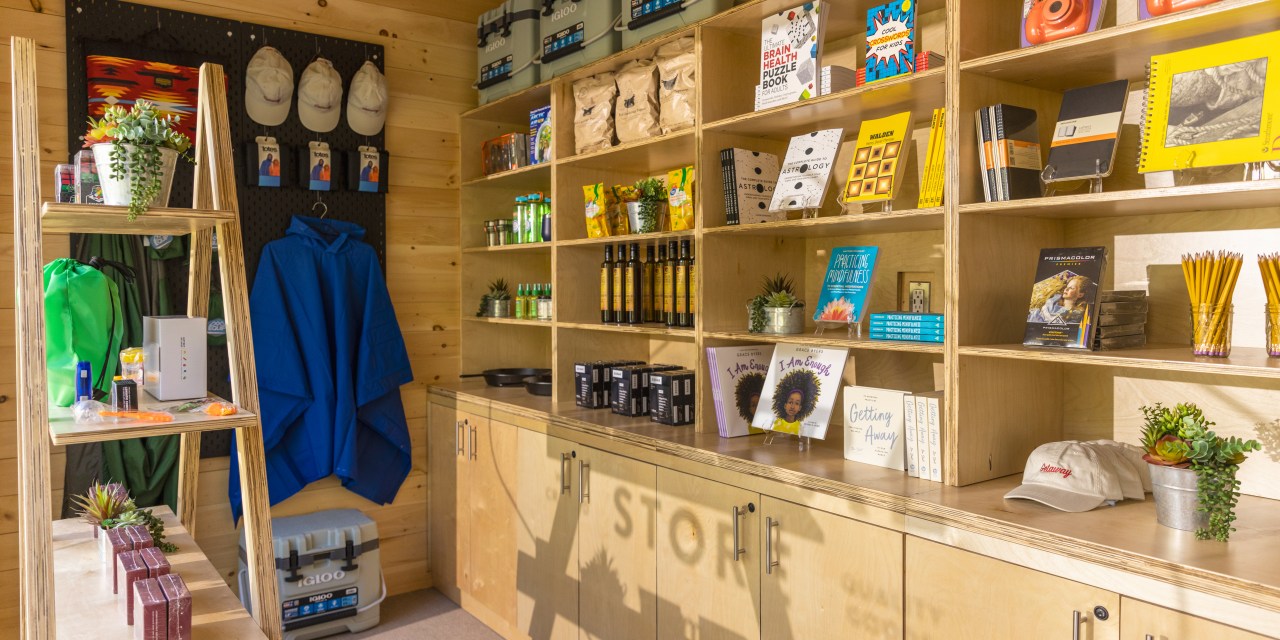 Walmart mini shop on Getaway outposts carry coolers, and camping gear like rain jackets and skillet on wooden shelves