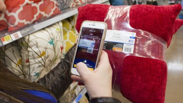 A woman uses her phone to scan her purchases