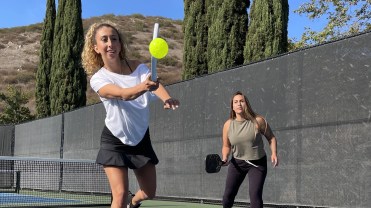 Two athletes play pickleball in Civile Apparel clothing