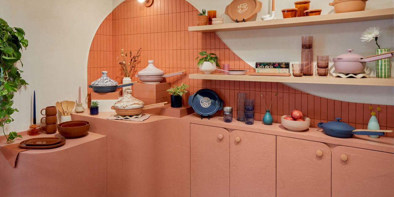 Pans and kitchenware stacked on a coral counter.