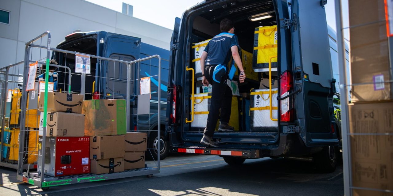 A driver loads the back of an Amazon truck.