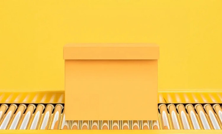 Yellow box on an assembly line, sitting on a yellow background