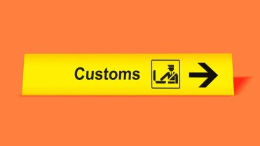 Bright yellow "customs" sign on an orange background.
