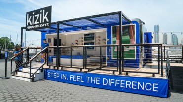 A blue Kizik trailer showing racks of shoes