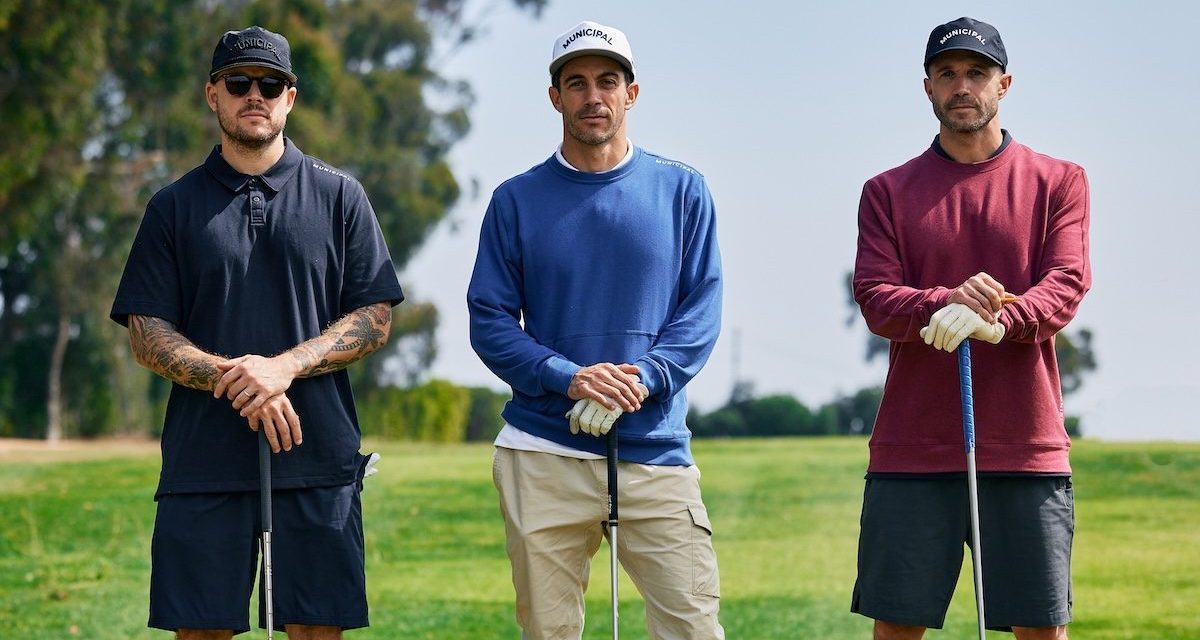 Three golfers stand on a course in Municipal clothing